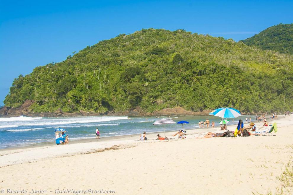 Imagem de pessoas na areia e carrinho de sorvete na Praia de Itamambuca.